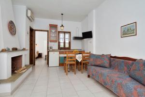 a living room with a couch and a table at House Katia in Kalamos +45 photos