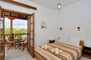 a bedroom with a bed and a balcony with a table at House Katia in Kalamos