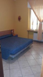 a bedroom with a bed with a blue comforter and a window at Mr Jackpot2 in Canelli