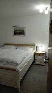 1 dormitorio con 1 cama y 1 mesa con mesita de noche en Gästezimmer Familie Müller, en Augustusburg