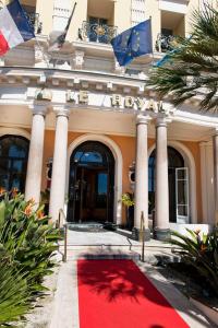 a red carpet in front of a building with flags at Hôtel Le Royal Promenade des Anglais in Nice