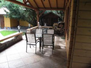 um pátio com uma mesa e cadeiras num pátio em Szypry - wakacyjny dom nad jeziorem em Barczewo