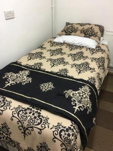 a bed with black and white sheets and pillows at Travelling Stop in Swindon