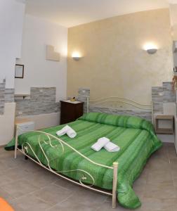 アヴェトラーナにあるCala del Conte b&bのベッドルーム1室(緑色のベッド1台、タオル付)