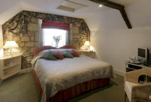 a bedroom with a large bed with a stone wall at Bath Place Hotel in Oxford