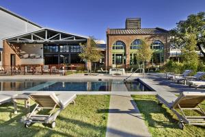 een zwembad met ligstoelen en een gebouw bij Cavalry Court, by Valencia Hotel Collection in College Station