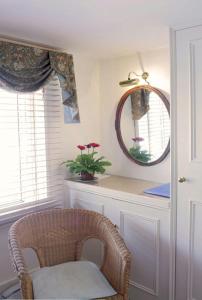 a room with a chair and a mirror and a window at Bath Place Hotel in Oxford