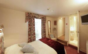 a bedroom with a bed and a window and a television at Bath Place Hotel in Oxford