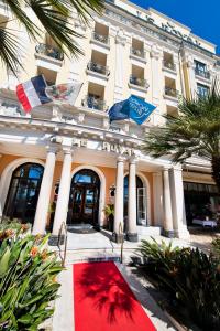 a building with a red carpet in front of a building at Hôtel Le Royal Promenade des Anglais in Nice