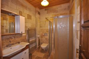 Un baño con ducha, lavabo e inodoro. en Cappadocia Stone Palace, en Göreme