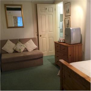 a living room with a couch and a tv on a dresser at Bath Place Hotel in Oxford +37 photos
