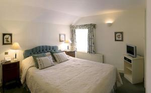 a bedroom with a large bed and a television at Bath Place Hotel in Oxford