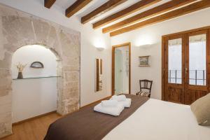 a bedroom with a large bed with white towels on it at Ramón Llull House in Palma de Mallorca