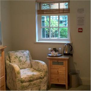 a room with a chair and a table and a window at Bath Place Hotel in Oxford