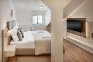 una camera con letto e TV a schermo piatto di Louren Apartments a Praga