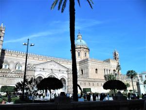 Un gran edificio con una palmera delante. en Le vie del Centro, en Palermo
