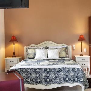 Un dormitorio con una cama blanca con dos lámparas. en A Casa Bella - Guesthouse, en Ilhabela