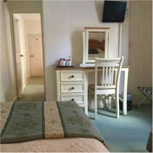 a bedroom with a desk with a chair and a mirror at Bath Place Hotel in Oxford