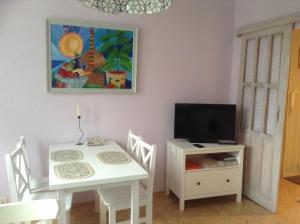a dining room with a white table and a television at Gabriela Apartment in Poznań