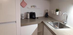 
a kitchen with a sink and a refrigerator at Pink house in Silves
