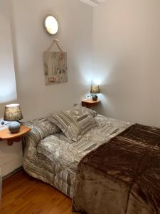 a bedroom with a bed and two tables with lamps at St JORDI CONF in Pas de la Casa