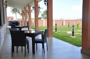 a dining room with a table and chairs and a lawn at Luwa Evergreen Hotel in Mtwara