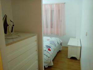 sypialnia z łóżkiem, komodą i oknem w obiekcie Apartamentos pandiellos I w Madrycie