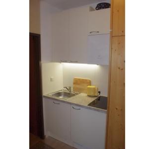 a kitchen with white cabinets and a sink at Ferienwohnung Klein&Fein in Bad Aussee