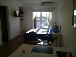 Una pequeña habitación con una cama y una ventana. en Apart Delacroix, en Santa Fe