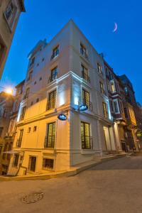 un grand bâtiment blanc dans une rue la nuit dans l'établissement Invictum Residence, à Istanbul