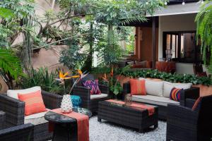 eine Terrasse mit Korbstühlen, Tischen und Pflanzen in der Unterkunft Hotel Ciudad Vieja in Guatemala