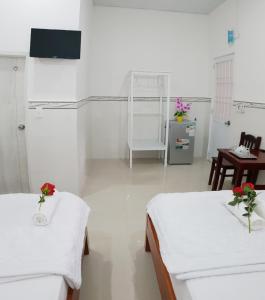 Habitación hospitalaria con 2 camas, mesa y sillas en Hai Phuong Tuyen Guesthouse, en Phu Quoc