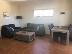 a living room with a couch and a table at The Sundowner Cabin & Tourist Park in Whyalla
