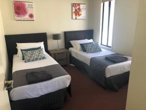 um quarto com duas camas com almofadas em The Sundowner Cabin & Tourist Park em Whyalla