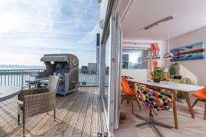 a balcony with a table and chairs and a grill at Bay Watch in Olpenitz