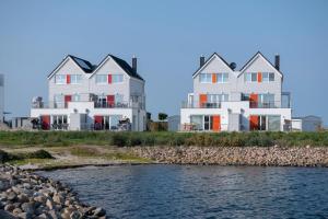 two large white houses next to a body of water at Bay Watch in Olpenitz