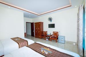 Habitación de hotel con 2 camas y escritorio en Ngoc Lan Hotel, en Cao Bằng