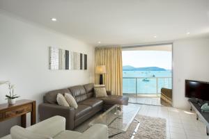 a living room filled with furniture and a large window at at Marina Shores in Airlie Beach
