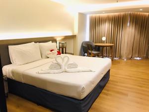 ein Hotelzimmer mit einem Bett mit Handtüchern darauf in der Unterkunft Sandy Spring Hotel in Pattaya