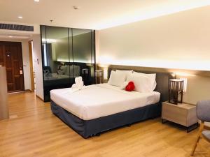 a bedroom with a large bed with a red pillow at Sandy Spring Hotel in Pattaya