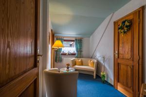a hallway with a living room with a couch and a table at Pension Fuhrmann's Elb- Café in Bad Schandau +5 photos