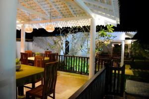 a restaurant with a table and chairs on a balcony at Odailem Resort - Talpe in Galle
