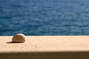 a rock sitting on a ledge near the water at Apartments AMORE in Bol