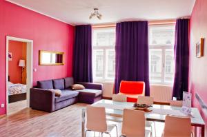 a living room with pink walls and a table and chairs at Royal Court Legerova in Prague