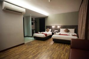 um quarto de hotel com duas camas e uma ventoinha em Katel Kuala Lumpur formally known as K Hotel em Kuala Lumpur