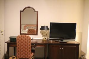 a room with a desk with a television and a mirror at NASPA New Otani in Yuzawa