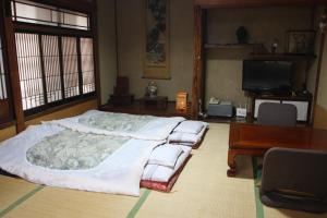 Postel nebo postele na pokoji v ubytování Yamadaya Ryokan
