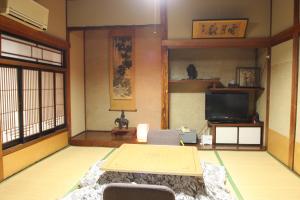 a living room with a table and a tv at Yamadaya Ryokan in Nozawa Onsen