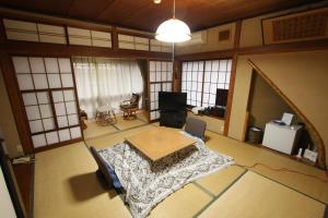 
a room with a bed, a desk and a window at Yamada-ya Ryokan in Nozawa Onsen
