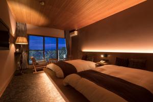 柳川的住宿－奧哈納酒店，一间卧室设有两张床和大窗户